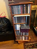 Full view of one side of rotating wooden media tower filled with CDs