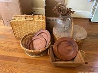 group of wicker baskets, wooden plates in basket, wooden crate, lidded wicker hamper, crackle-glass pitcher