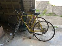 Both yellow Azuki bicycles leaning in garage