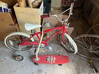 Full view of bicycle with training wheels and scooter in front