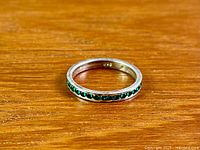 Ring top view showing continuous green stones