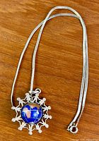 Pendant and chain full view on wooden surface