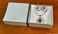 Box showing Freyja Collection lid and set inside: necklace and two earrings