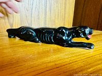 Full side view of entire panther figurine on shelf