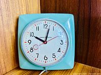 Front view of mint green GE Skytimer wall clock showing dial and hands