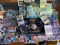 Overview of loose cards, unopened packs, signed baseball, storage case