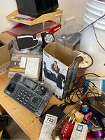Overview of electronics on table including VTech phone box, base phone, spotlight, door lock, dimmer packages and cables