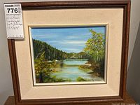 Front view of framed oil landscape painting with MaxSold tag
