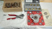 Overall view of molding head cutter set, router bushings case, hole punch pliers, wooden box of dies
