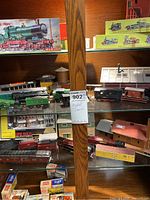 Shelf with multiple assembled locomotives, cars, buildings and boxed kits
