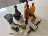 Group shot showing all bottles, pipes, tap handle, cup and ashtray