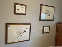 Wall showing four framed prints; two larger Benjamin CheeChee prints are the lot items