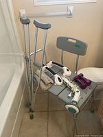 Overall lot showing shower bench, crutches, grab bars, ankle weight, massager, dumbbells