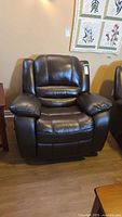 Front view of dark brown leather recliner showing overall design and condition