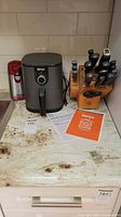 Overview of Ninja air fryer, Starfrit can opener and knife block on countertop