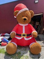 Full view of inflated Santa teddy bear against building