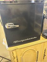 Front view showing black exterior, chrome handle, brand script