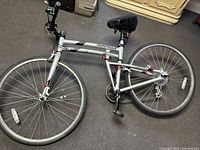Full view of folded Montague Crosstown bicycle showing frame, wheels, handlebars and saddle