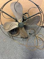 Front view showing brass blades, wire cage, cloth cord