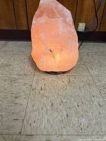 Front view of illuminated Himalayan salt lamp on base