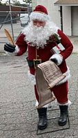 Full view of 6-foot Santa figure holding quill and scroll on stand