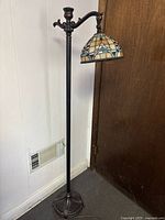 Full view of floor lamp showing stand, arm and shade