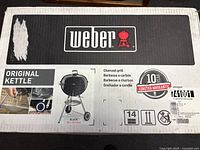 Sealed retail box front showing Weber Original Kettle 22-inch charcoal grill, model and warranty details