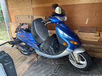 Left side view of blue Kymco scooter in storage