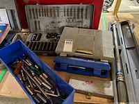 Overall lot showing torque wrench, socket cases, blue bin with loose tools