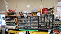 Wide view of two organizer cabinets, drill bit boxes and assorted hardware