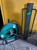 Fish tape reel and post driver standing together