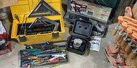 Wide view of lot showing toolbox, power tools in cases and hand tools