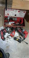 Five Milwaukee corded tools and metal case on floor