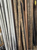 Group of steel pipes, rods and flat bars showing mix of galvanized and rusted finishes