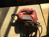 Full view of Black & Decker red jigsaw on table