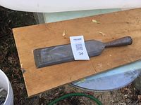 Full view of the stone chisel on a wooden board