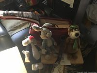 Canon leather camera bag with shoulder strap and three plush toys displayed on table