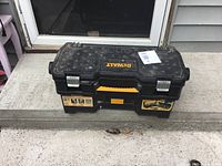 Closed DeWalt toolbox front view on concrete step