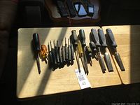 All screwdrivers and chisels laid out on table