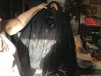 Full view of front of black winter coat on hanger