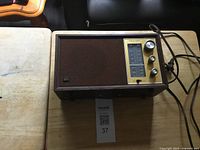 Front view of Realistic MTA/8 radio on table showing speaker grille, control panel, cord