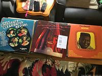 Front view showing Creedence Clearwater Revival, unidentified guitar album and Fats Domino records on top of stack