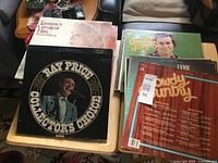 Stack of vinyl LPs on table; visible Ray Price, Tammy Wynette, George Jones, Lynn albums