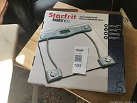 Front of unopened Starfrit Balance glass digital scale box showing product image and specifications