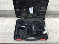 Entire open case showing tool, attachments and handle in place