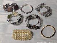 Overview of all eight bracelets laid out on surface