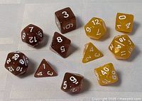 Group shot of brown and yellow polyhedral dice on fabric backdrop