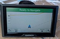 Front view of Garmin GPS powered on displaying navigation screen