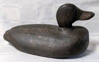 Left profile of carved wooden black duck decoy