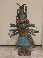 Full view of metal Kachina sculpture standing upright